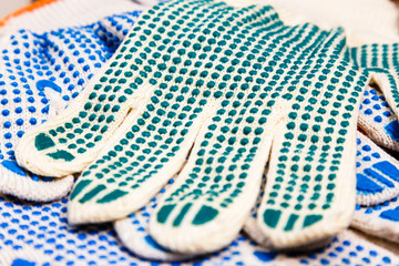 Thin work gloves with green pimples close up.