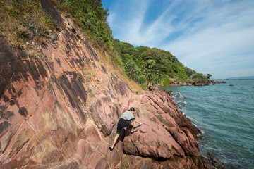 woman climb on pink stone beach , Chantaburi in Thailand