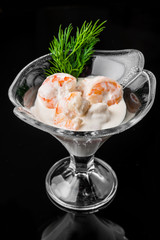 shrimp cocktail with white sauce, in a tall glass on a black background