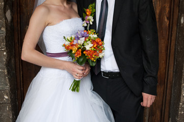 Obraz na płótnie Canvas Beautiful bride and groom with bouquet before wedding ceremony