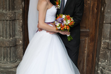 Beautiful bride and groom with bouquet before wedding ceremony
