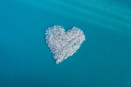 heart, laid out rice on a blue rustic background, top view, valentines day, place for text
