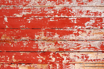 Ancient wood with cracked paint of red color