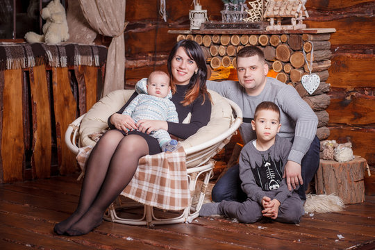 Young family with two children near fireplace celebrating Christ