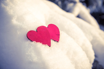     Two red hearts lie on the snow 