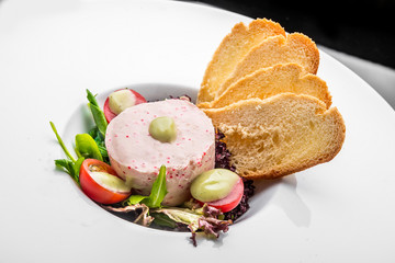 Smoked salmon and soft cheese spread, mousse, pate in a jar with crackers, olives and capers on a wooden background