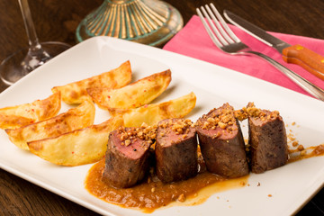 Close up of forest animal steak with potatoes and a glass of win