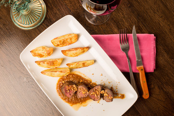 Close up of forest animal steak with potatoes and a glass of win