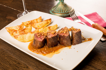 Close up of forest animal steak with potatoes and a glass of win