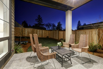 Backyard covered patio design with high back wicker chairs