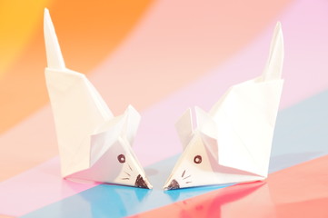 Paper origami mouse isolated on the colorful background
