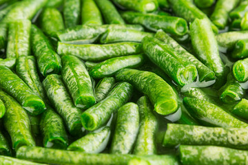 Wet fresh green french bean in water  closeup as background. Healthy vitamin food.