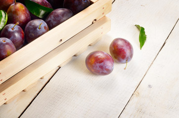 Wooden crate with plums