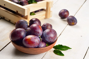 Clay plate with plums closeup