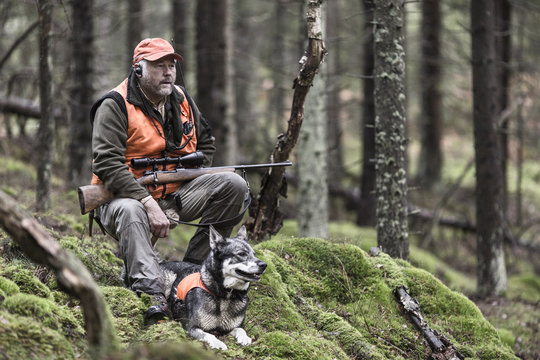 Hunter with dog in forest
