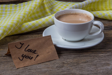 Note I love you with cup of coffee on wooden background