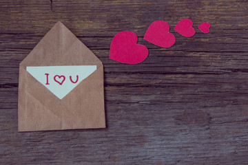 Envelope with card and text I love you and red hearts for valent