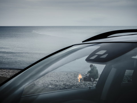 Man at campfire on beach