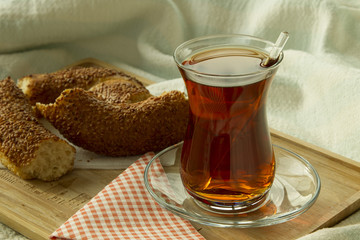Morning turkish tea in traditional glass with bagel on the tray,