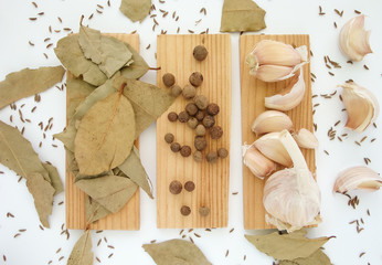 Herbs and spices selection. Top view. From above. Bay leaves, pepper and garlic on white background.
