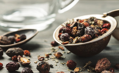 Herbal tea in metal stainer with silver spoon