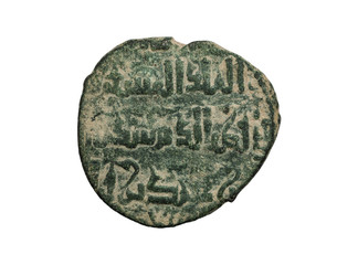 Islamic ancient copper coin with rows of letters on it isolated on white