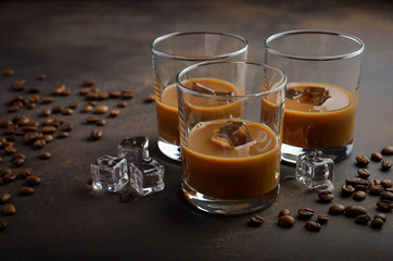 Glass of Coffee Liqueur with ice on the old rusty background, selective focus, copy space