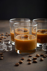 Glass of Coffee Liqueur with ice on the old rusty background, selective focus, copy space