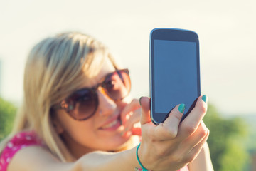 Girl making selfie outdoors.
