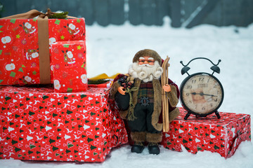 gifts, clock and a red retro car in snowy winter day