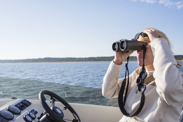 Woman on boat looking through binoculars
