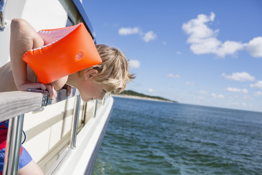 Boy on boat looking at sea