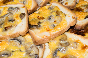 Fette di pancarrè tostate e condite con funghi, formaggio e uovo 