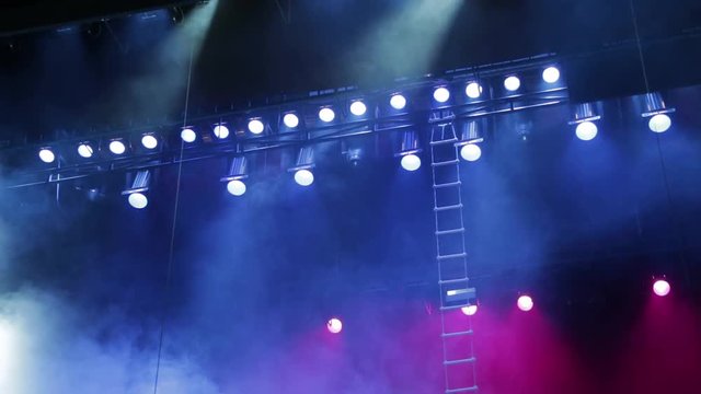Lighting equipment on the stage. Smoke and blue and red spotlights. The musical show, concert, performance.