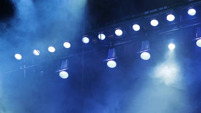 Lighting equipment on the stage. Smoke blue in the spotlight. The musical show, concert, performance.