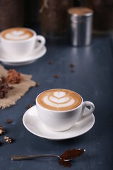 Two cups of coffee on a blue background