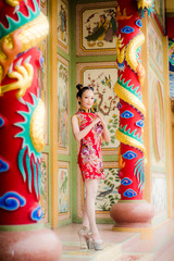 Beautiful  Asian girl wear cheongsam and show something to you in chinese new year