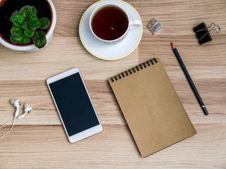 Wooden table with a smartphone and a Cup of tea. The view from the top