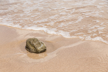 Fototapeta na wymiar Small stone on sand beach