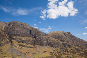 White clouds over Scottish mountains in spring with sunshine Glencoe Scotland UK famous tourist destination