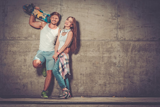 Cheerful couple with with skateboard outdoors