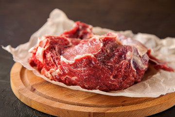 piece of raw meat of beef on a board with spices, selective focus, copy space, dark photo