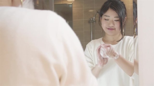 Beautiful Japanese women dashing drying clean hands in mirror 