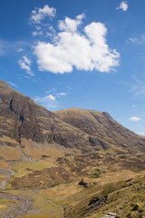 White clouds over Scottish mountains in spring with sunshine Glencoe Scotland UK famous tourist destination