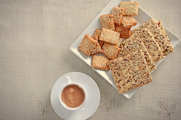 Cereal cookies with cup of coffee on tablecloth
