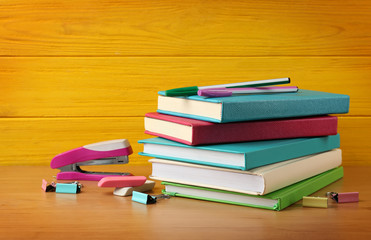 Colorful books and accessories on wooden background