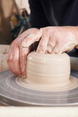 Close Up Of Potter Moulding Clay On Wheel