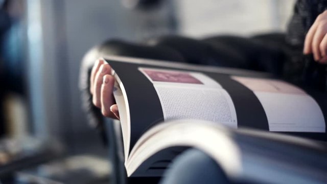 Casual man read a glossy magazine. indoor, close up