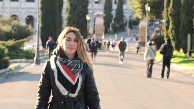 Happy beautiful woman walking near Coliseum in Rome, selective focus