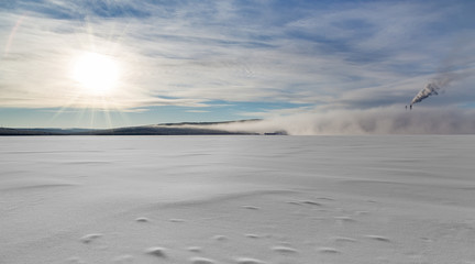 winter landscape with smoking chimneys in fog